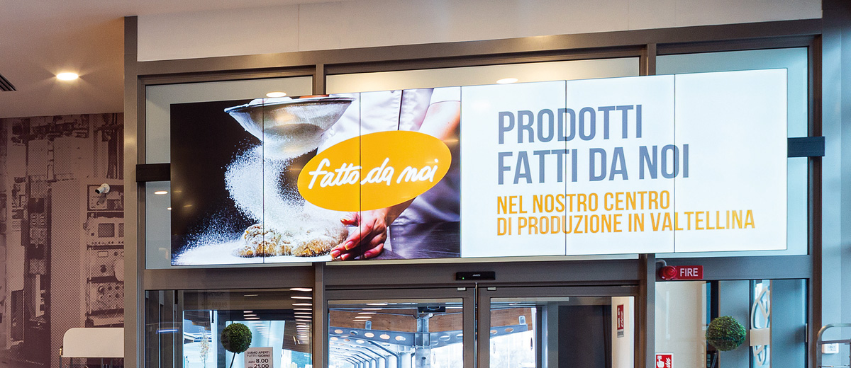 Iperal — videowall all'ingresso del supermercato